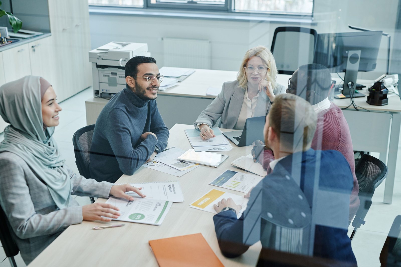 Coworkers talking face to face around an office meeting table